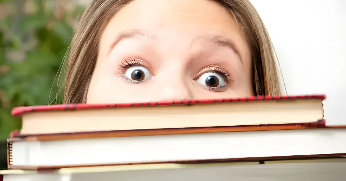 Cena sombria com livros de horror empilhados, evocando suspense e medo